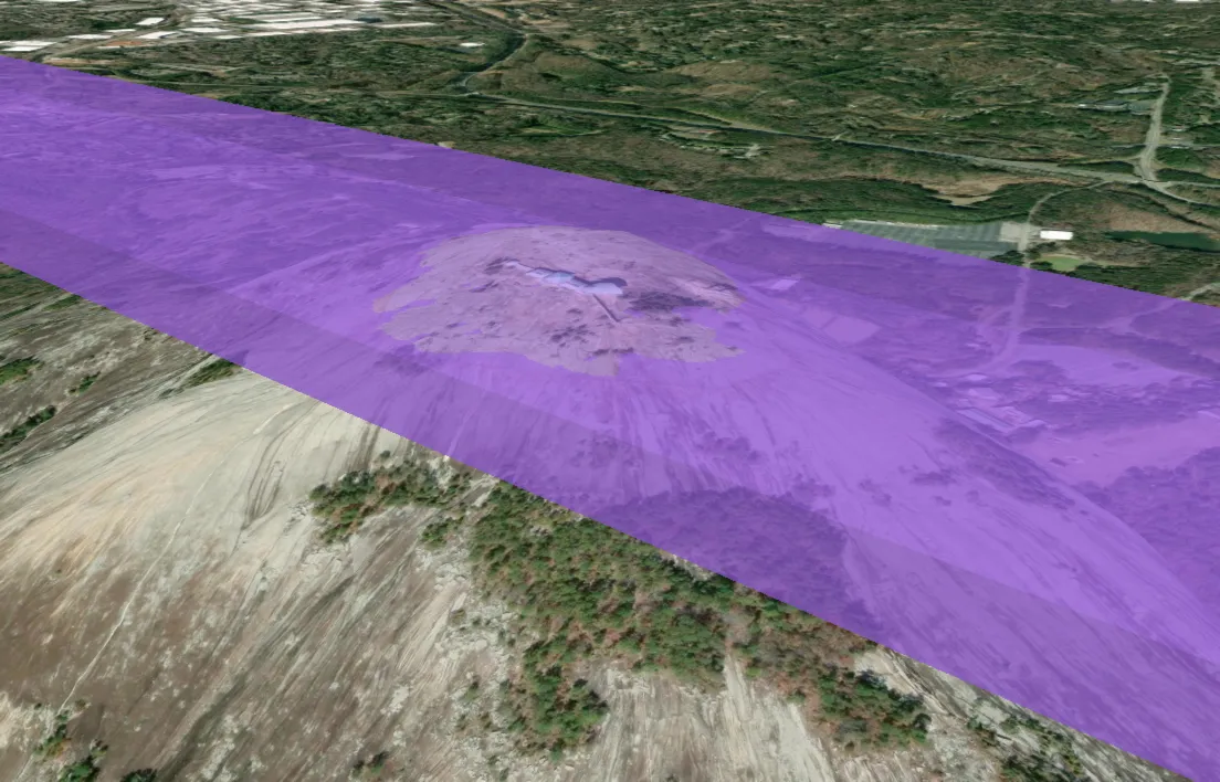 A flat centroid-sampled airspace slab rendered over Stone Mountain in Cesium, visibly floating above the terrain on one side and clipping into the mountain on the other